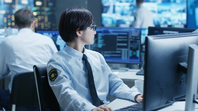 In the Security Command Center Officer at His Workstation Monitors Multiple Screens for Unlawful Infiltration. They're Guarding Important International Logistics Facility. 