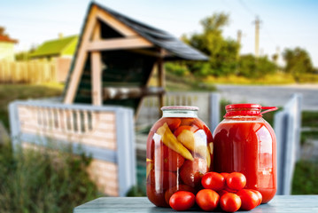 pickles tomatoes against the backdrop of a rural well