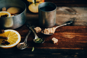 Mulled wine hot drink with citrus, apple and spices in aluminum casserole and Fir branch on concrete background
