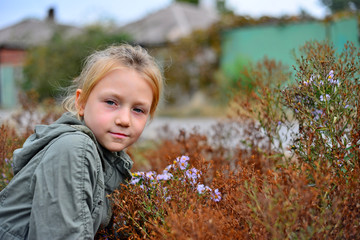 Vintage portrait of a cute little girl smelling a flower