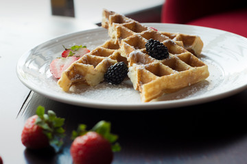 Waffles with Strawberries and Blackberries on wooden table