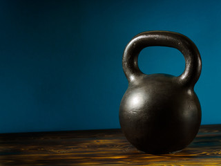 Weights on a wooden floor and blue background.