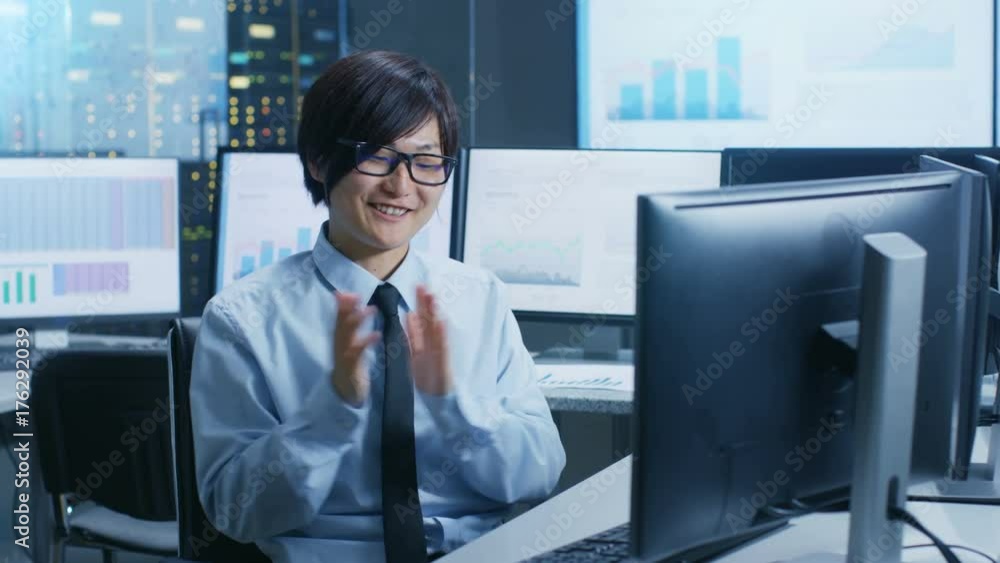 Fototapete in the data mining center statistician claps his hands while sitting at his workstation surrounded w