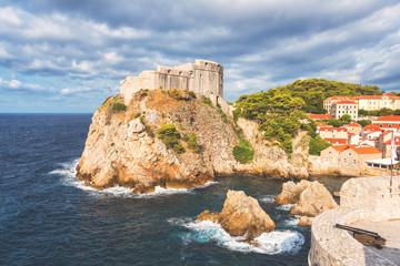 Fototapeta na wymiar Dubrovnik medieval fortress Lovrijenac (St. Lawrence) on the rock, beautiful landscape with blue cloudy sky and Adriatic sea, popular view from the ancient city wall, Croatia