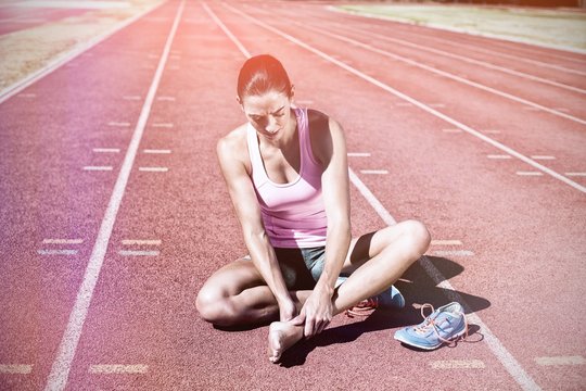 Female Athlete With Foot Pain On Running Track