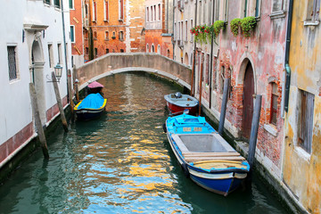 Fototapeta na wymiar Boats moored in a narrow canal in Venice, Italy