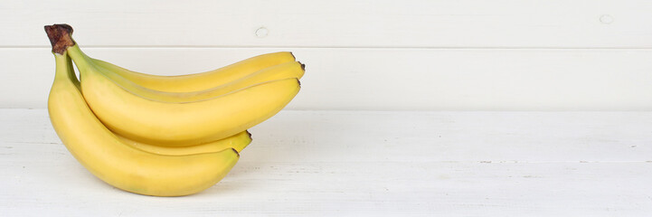 Bananen Frucht Früchte Banner Textfreiraum auf Holzplatte