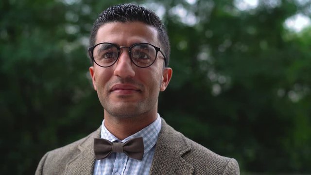 Portrait of a young Arab smiling man in glasses. Slow motion