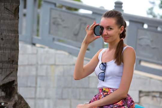 A girl posing with a light filter lens in the park. A woman in Sanya, Hainan, China.