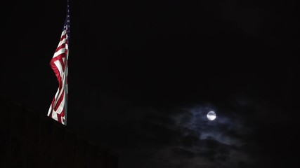 American flag in front of a cloudy full moon at night - Powered by Adobe