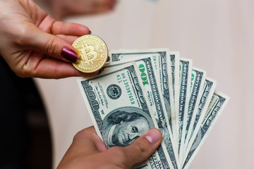 Golden bitcoins on us dollars in the hands electronic money exchange concept