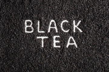 Inscription black tea created on dried, loose tea. Enjoying of tea break at the work, at home, at visit with friends, family or alone everyday. Top view.