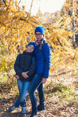 Fototapeta na wymiar Mother and son at autumn park in sunny beauty day