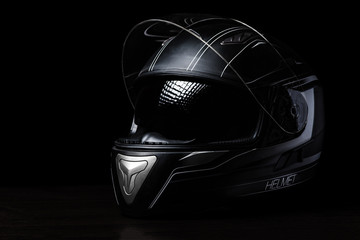 A black motorcycle helmet on dark background.