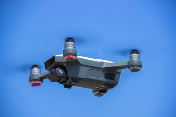 White quadrocopter hovers in the sky. Modern technology photo and video shooting.