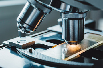 Close-up shot of microscope with metal lens at laboratory.