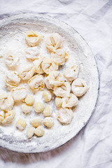 Fresh tortellini and gnocchi italian pasta white linen background