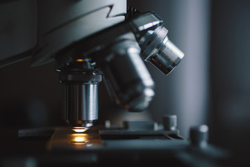Close-up shot of microscope with metal lens at laboratory.