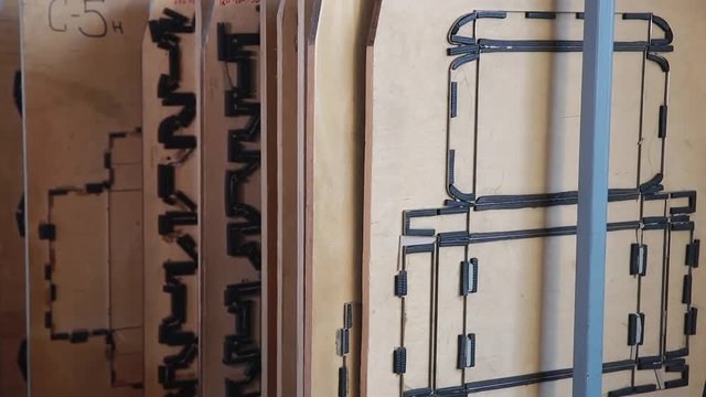 Close up box die cutting mold on manufacture of cardboard boxes. Mold for a cardboard box. Carving of a cardboard box by means of a mold under a press. Paper corrugated box factory.