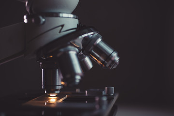Close-up shot of microscope with metal lens at laboratory.