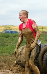 The girl gets up after the emotional overcoming of the obstacle made of tires.