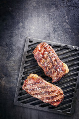 Two barbecue dry aged Kobe roast beef as close-up on a grillage with copy space