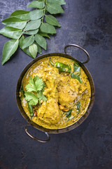 Traditional Indian curry chicken as close-up in a korai