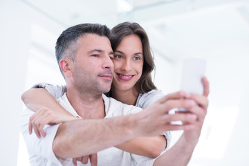 happy couple using mobile phone at home