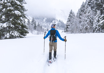 Man Snowshoeing Through a Winter Scene