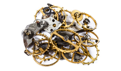 The details (gears, springs, pendulums) of the clockwork in a pile on a white background. Selective focus.
