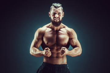 Very brawny guy bodybuilder posing. Beautiful sporty guy male power. Fitness muscled man in studio....