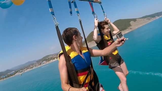 ocean paragliding and parasailing lifestyle. man and boy are flying on a parachute over the sea. Extreme sport first-person view