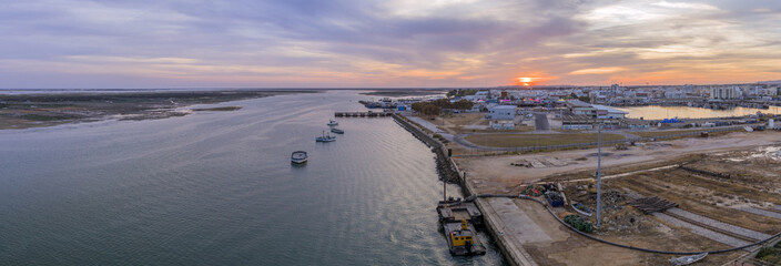 Sunset aerial panoramic seascape view of Olhao dockyard, waterfront to Ria Formosa natural park and Armona island. Algarve.