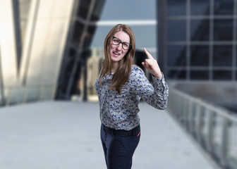 Pretty young business woman making horn gesture