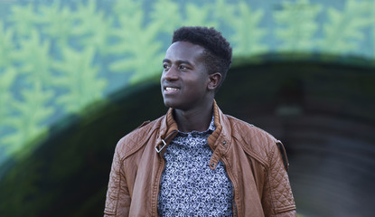 Handsome young black man smiling in front of an underpass