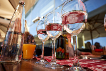 Row of pure drinking water glasses at summer terrace cafe.