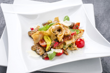 Traditional Italian pappardelle alla cozze with mushrooms and parmesan as close-up on a plate