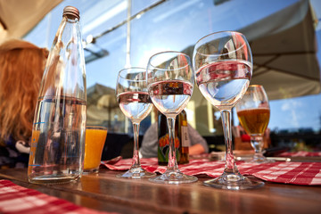 Row of pure drinking water glasses at summer terrace cafe.