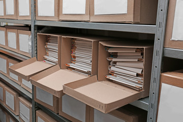 Cardboard boxes with documents on shelving unit in archive