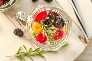 Mason jar with fresh rosemary drink on wooden board
