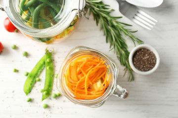 Mason jar with tasty carrot salad on table