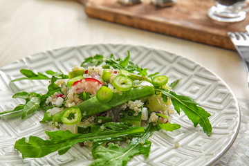 Plate with quinoa salad on table, closeup
