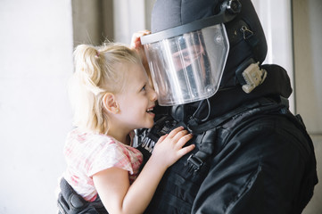 special policeman holding a little girl in his arms