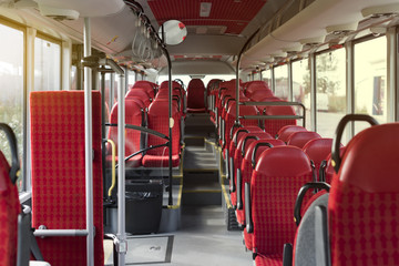 The interior of a new public transportation bus with red seats