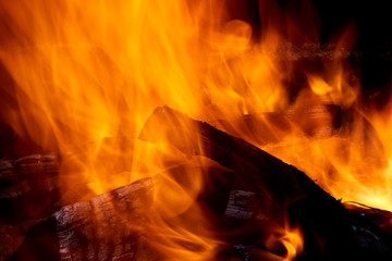 Burning firewood in the fireplace close up photo.