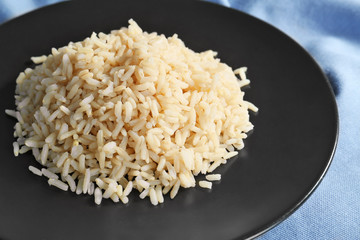 Plate with cooked rice on table