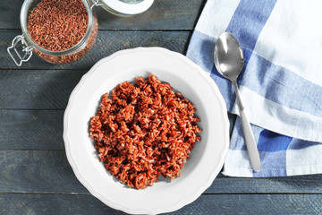 Plate with cooked rice on table