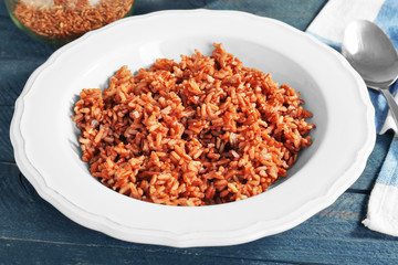 Plate with cooked rice on table