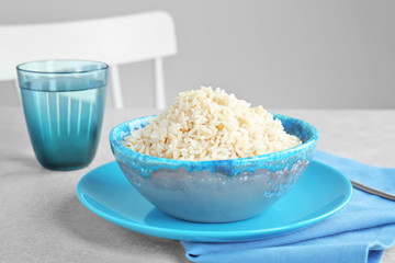 Dish with cooked rice on table