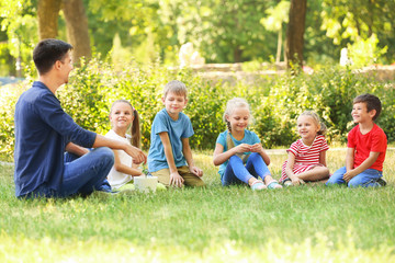 Naklejka na ściany i meble Group of children with teacher in park on sunny day